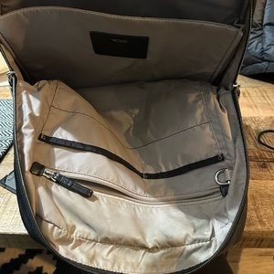 Tumi backpack also converts to handbag handles which are leather.